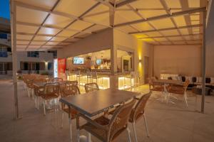 阿莫迪Remezzo Studios & Apartments的一间带桌椅的餐厅和一间酒吧