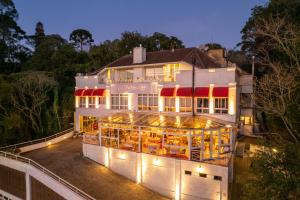 格拉玛多Le Boutique Hotel Gramado - Exclusivo para Casais的一座白色的大建筑,有红色遮阳篷