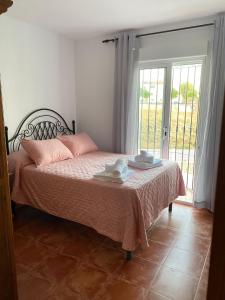 内尔哈Villa Jara 25的一间卧室配有一张带粉色床单的床和一扇窗户。