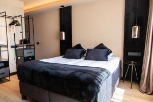 赞德沃特帕勒斯赞多特酒店的卧室配有一张大床,提供黑色床单和枕头。
