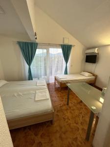克拉西奇Krašići apartmani Bozic的小房间设有两张床和窗户