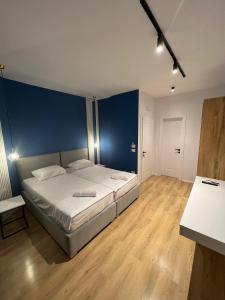 地拉那Capital Suites Center的一间卧室配有一张蓝色墙壁的床