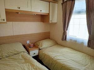 普利斯坦丁2 Bedroom Static Caravan C3 on quiet park near Talacre and Prestatyn的小型客房 - 带2张床和窗户