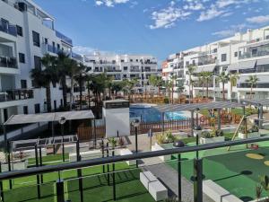 莫特里尔Playa & Golf Deluxe en Playa Granada的享有带高尔夫球场的公寓大楼的景色