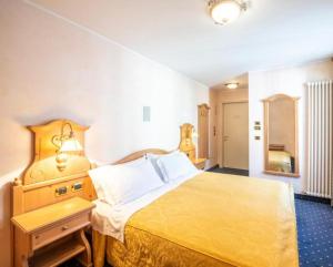 费拉迪普利米罗雷莱奥辛赫酒店的一间卧室配有一张带黄色床罩的大床