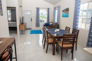 迪斯卡弗里贝OceanView Villa的用餐室以及带桌椅的起居室。