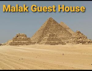 开罗Malak Guest House的沙漠中一群金字塔,上面写着“疟疾”的旅馆