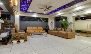 古尔冈Treebo Trend Nearmi Bell House Sec 47的带沙发的客厅和带紫色灯的天花板