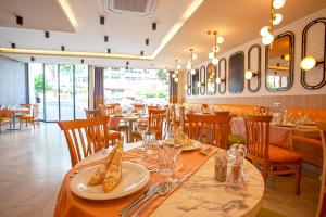安塔利亚Old Town Point Hotel & Spa Antalya的餐厅设有长桌,配有盘子和玻璃杯