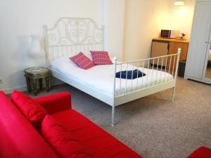 海牙Irene's Palace的一间卧室配有一张床和一张红色的沙发