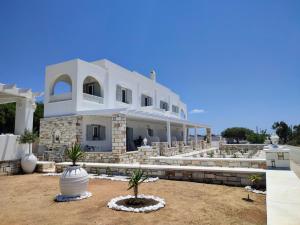 纳克索斯岛卡斯特拉基Sea and Salt Naxos 3的一座白色的大建筑,前面有棕榈树