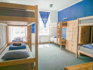 里加希娜蒙莎莉背包客旅馆的客房设有三张双层床和蓝色的墙壁。