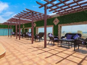 阿可贺巴هوليداي الخليج الخبر Holiday Al Khaleej Hotel的一个带椅子和绿色墙壁的庭院
