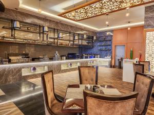 阿可贺巴هوليداي الخليج الخبر Holiday Al Khaleej Hotel的一间带桌椅的餐厅和酒吧