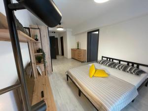 布加勒斯特Moghioros Park Residence DUM3的一间卧室配有一张带黄色枕头的床。