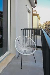 西维尔诺瓦·马尔凯LE MARIN contemporary apartments的坐在大楼阳台上的白色椅子