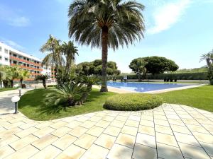 坎布里尔斯LuxuryCambrils Resort&Spa的棕榈树和游泳池的度假村