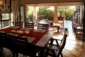 玛洛斯帕克Eden Safari Country House的一间带木桌和椅子的用餐室