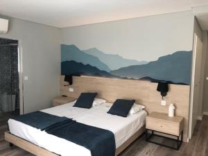 瓜尔达Hostel S. Miguel FitNCare的卧室配有一张大床,墙上挂着群山