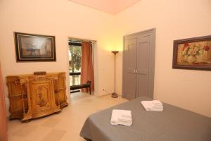 库特罗菲安诺Villa Lucrezio Resort的一间设有床铺的房间,上面有两条白色毛巾