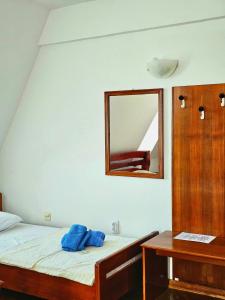 Novi KneževacRestoran Lovac的卧室配有一张壁挂镜子的床