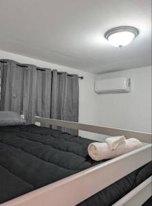 阿雷西博Family-Home-Workplace-Peace的一间卧室设有一张黑色大床和窗户