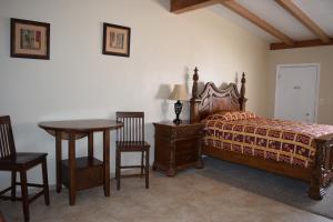 德明BUTTERFIELD STAGE MOTEL的卧室配有一张床和一张桌子及椅子
