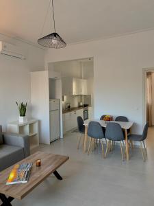 利吉亚Lýria Boutique Apartments的一间带桌椅的客厅和一间厨房