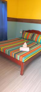 爱妮岛ALFA Beach Front Lodge的一张带五颜六色毯子和帽子的床