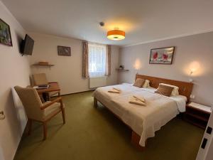 哈拉霍夫博得斯莫科姆旅馆的一间卧室配有一张床、一张桌子和一把椅子