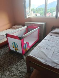 蒂瓦特Dena apartman Tivat的儿童卧室配有两张床和一张婴儿床