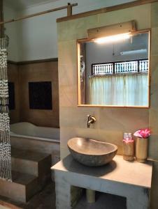 罗威那Kaia Lovina Guest House Junior Suite的一间带一个碗水槽和浴缸的浴室