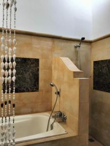 罗威那Kaia Lovina Guest House Junior Suite的设有带浴缸和淋浴的浴室。