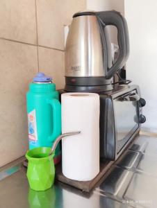 波萨达斯Departamento monoambiente hasta 4 personas- Maragus2的咖啡壶和一卷纸质毛巾及绿杯