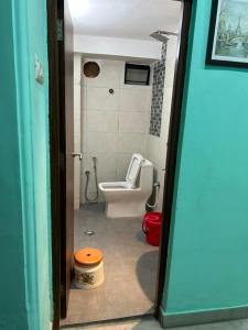 加尔各答Teakwood Suite - Nokha House的一间带卫生间、水槽和门的浴室