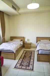 安曼شقة فاخرة و واسعة من 4 غرف مع وسائل الراحة الحديثة Spacious 4-Room Apartment with Modern Amenities的卧室配有两张床,地板上铺有地毯。