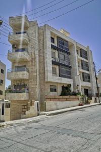 安曼شقة فاخرة و واسعة من 4 غرف مع وسائل الراحة الحديثة Spacious 4-Room Apartment with Modern Amenities的街道边的建筑物