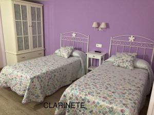埃尔希耶戈阔西亚卡萨乡村民宿的一间卧室设有两张床和紫色的墙壁