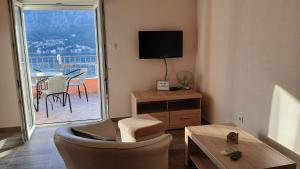 科托尔Apartments Krivokapic Kotor的客厅配有电视和桌椅
