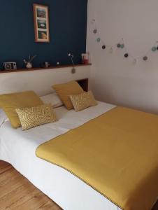 Blainville-sur-OrnePEGASUS的一张配有黄色和白色床单和枕头的床