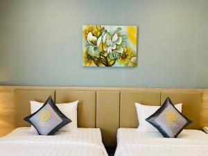 胡志明市Hera Luxury Hotel的墙上画画的房间里设有两张床