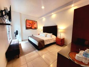 莫雷利亚Casa Allende Morelia的酒店客房配有一张床铺和一张桌子。