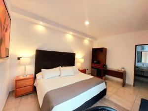 莫雷利亚Casa Allende Morelia的一间卧室配有一张床、一个梳妆台和一扇窗户。