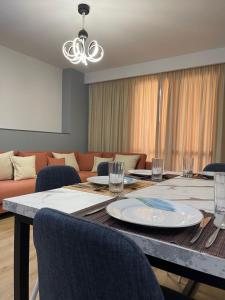 卡瓦亚Shehapi apartment的用餐室配有桌椅和沙发