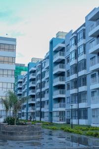 思由基茅Indesign Makumbi park studio Apartment D4-5,Syokimau的一座蓝色的公寓楼,前面有棕榈树