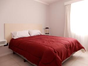 圣罗莎Edificio Parana的一间卧室配有一张红色的床和窗户