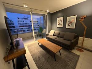 圣地亚哥Oceana Suites Capital, vista a la ciudad的客厅配有沙发和桌子