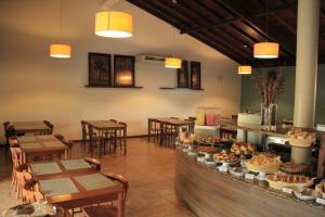 塞古罗港普拉亚萨拉纳酒店 的一间带桌椅和食品柜台的餐厅