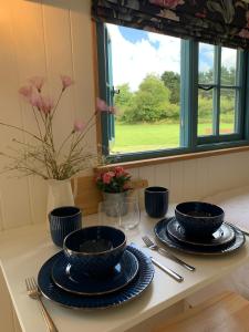 韦德布里奇St. Kew Shepherd Huts的一张桌子,上面有两个蓝色的碗和盘子