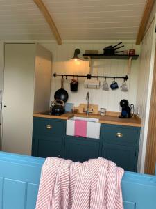 韦德布里奇St. Kew Shepherd Huts的厨房配有蓝色橱柜和水槽